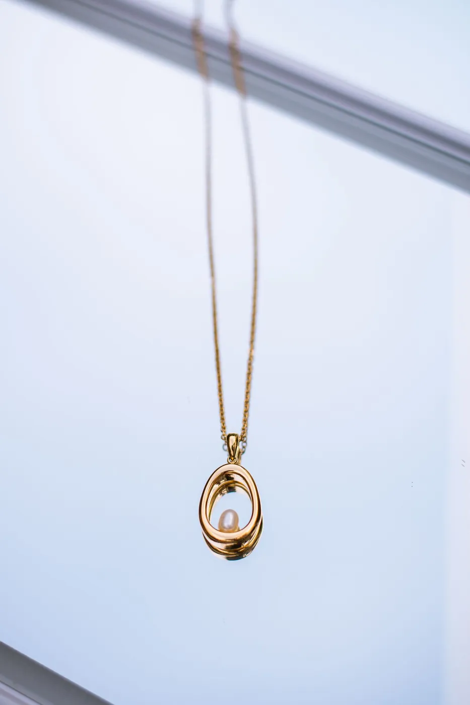 Pendentif doré orné d'une perle